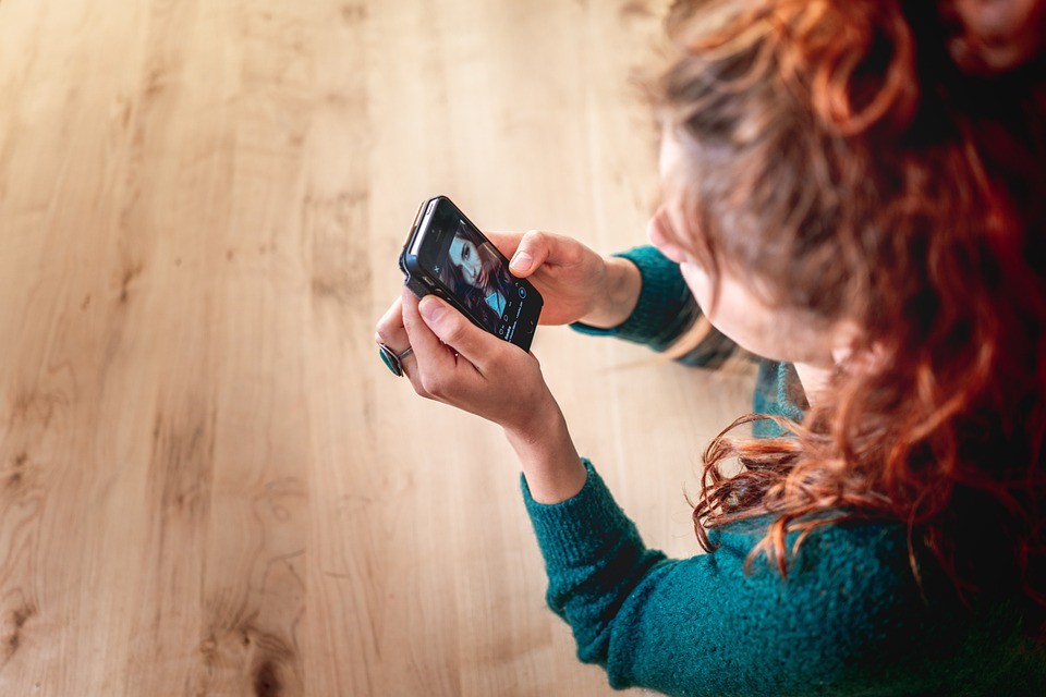A woman browsing through Instagram on her smartphone