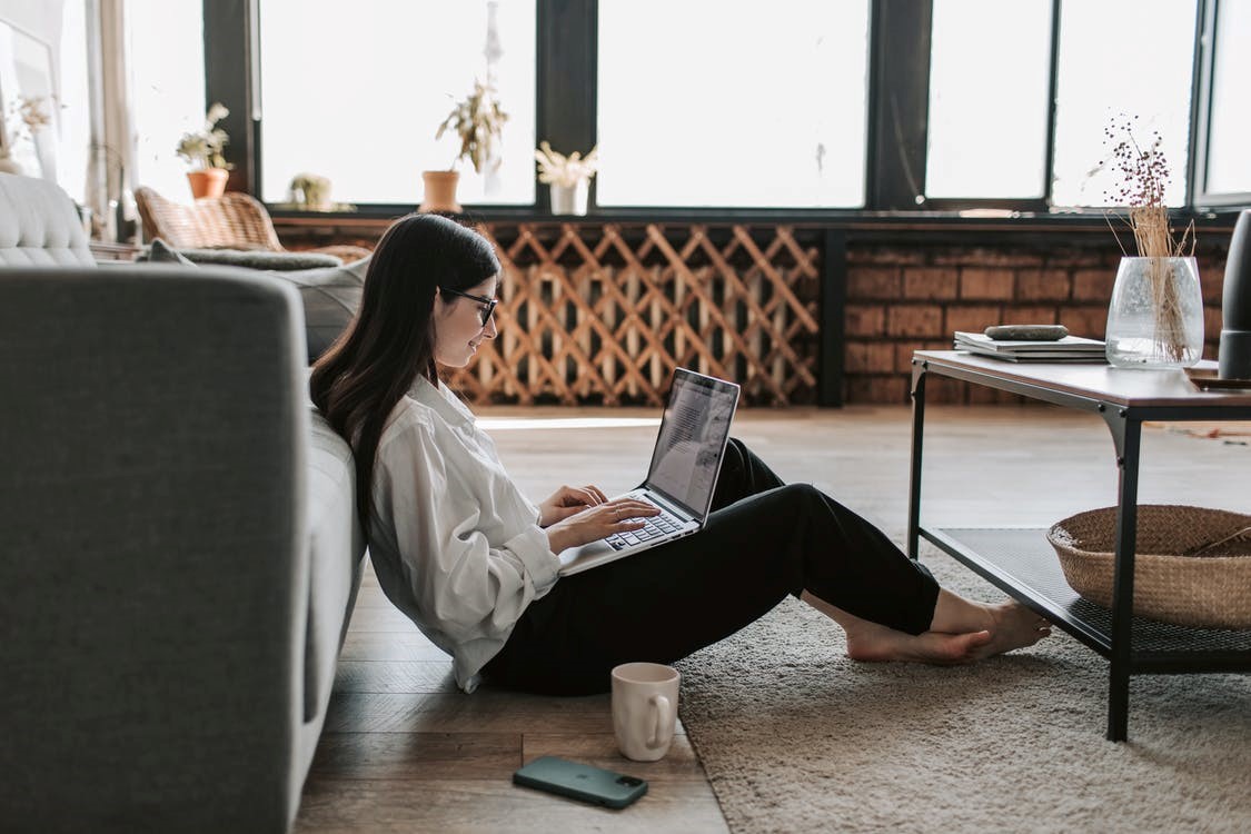 Woman browsing the web on her laptop at home during the COVID-19 pandemic