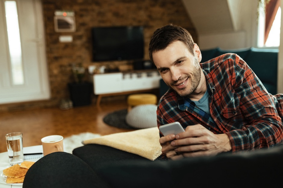 A man in a plaid shirt holding a phone.