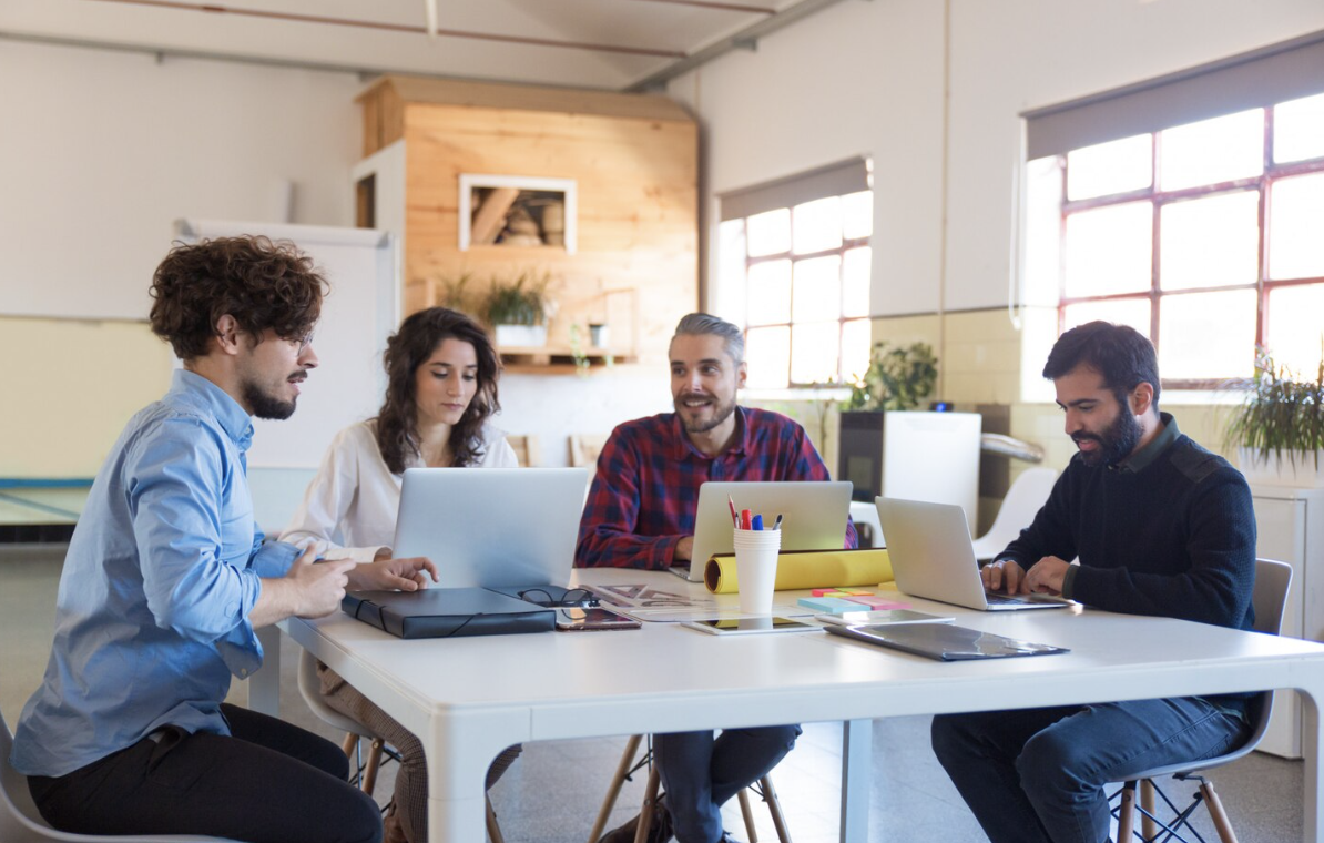 A team of digital marketing professionals working together on a link building campaign at an office desk